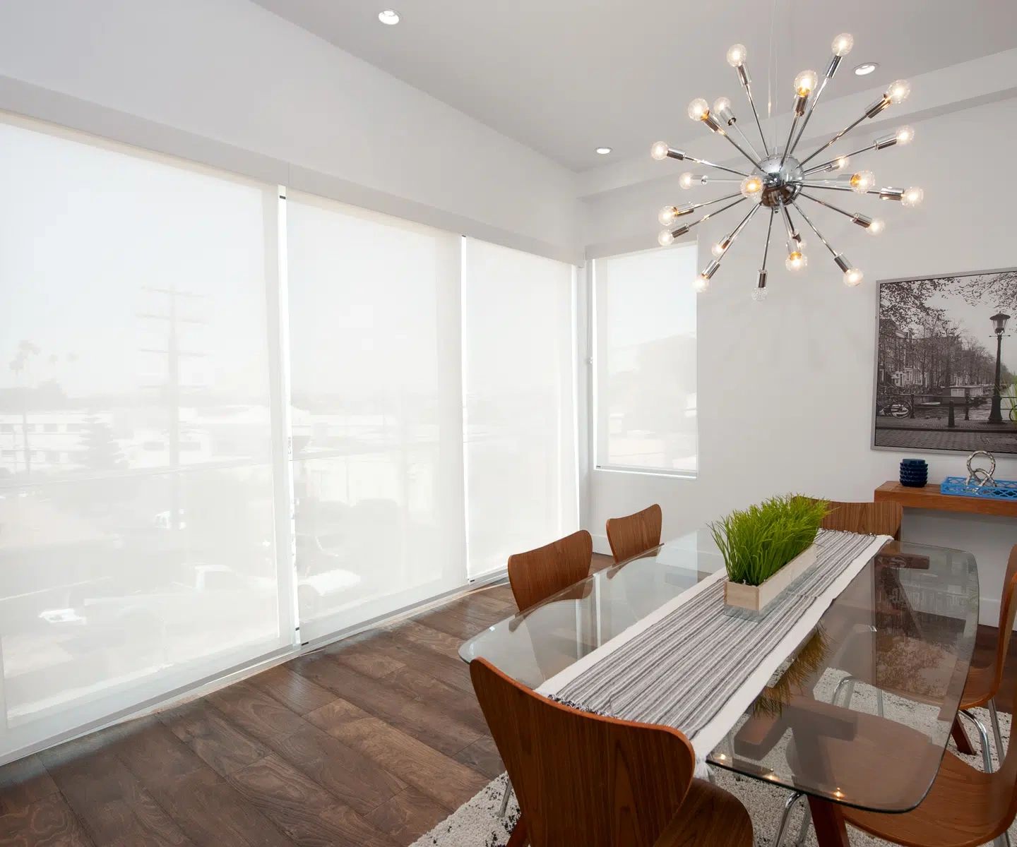 Modern dining room with roller shades and floor-to-ceiling windows