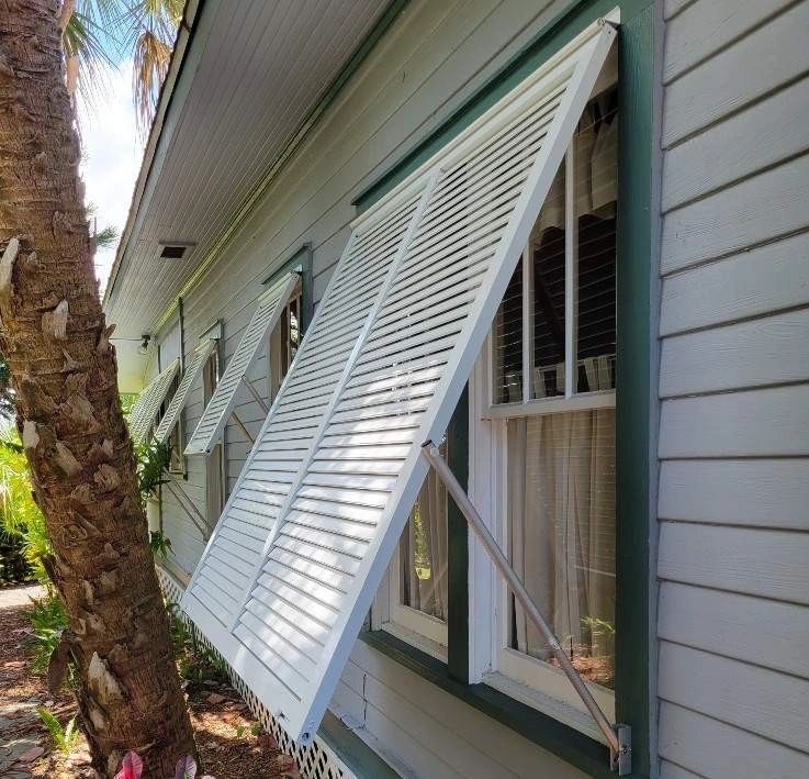 Bahama hurricane shutters on a coastal home exterior